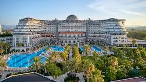 Antalya Havalimanı'ndan Kızılot bölgesine VIP ulaşım sağlayan lüks Mercedes Vito araç, arkaplanda Crystal Admiral Resort ve Kızılot'un bakir kum-çakıl plaj manzarası.